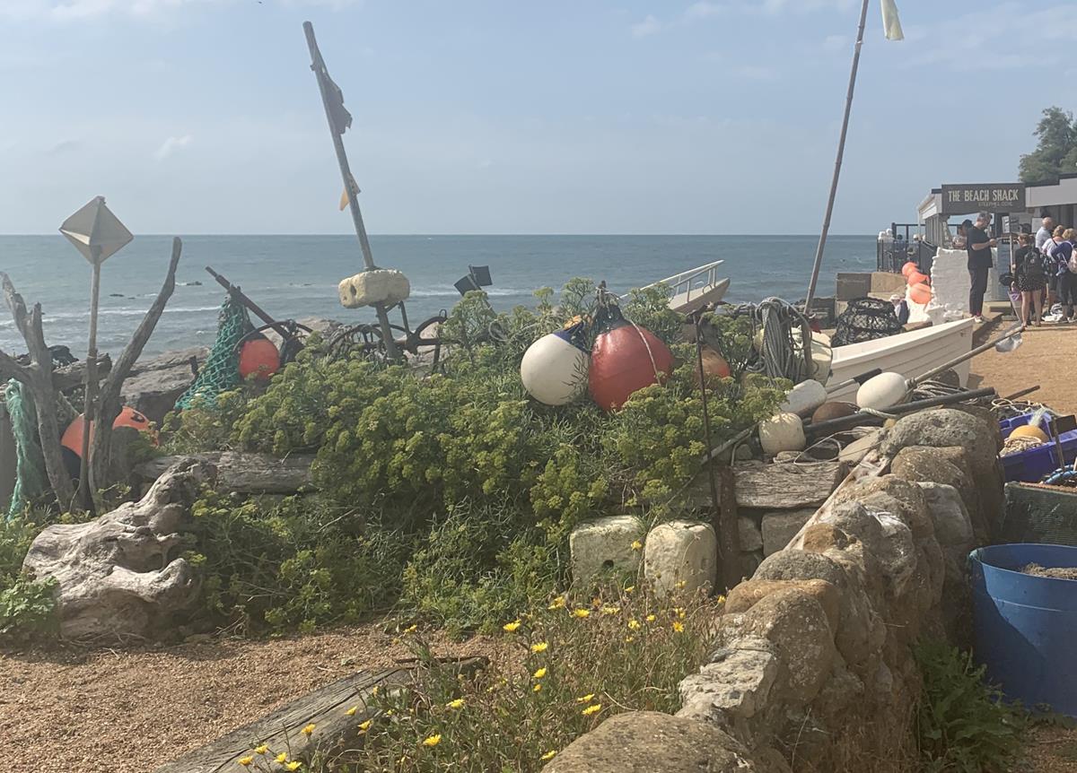 Steephill Cove, Isle of Wight. View of beach shack, stone wall, and visitors.